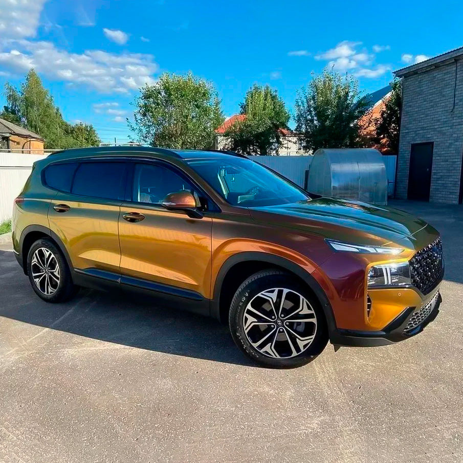 Side angle of an SUV wrapped in TeckWrap Ruby Gold (RD13-HD) Gloss Vinyl Wrap, highlighting the vivid ruby and rich gold hues under sunlight.