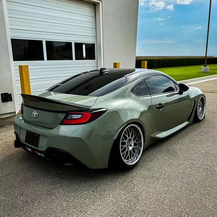 Rear-side view of lowered Toyota GR86 wrapped in TeckWrap Moss Green CG23-HD Glossy Vinyl, featuring deep gloss and modern appeal.