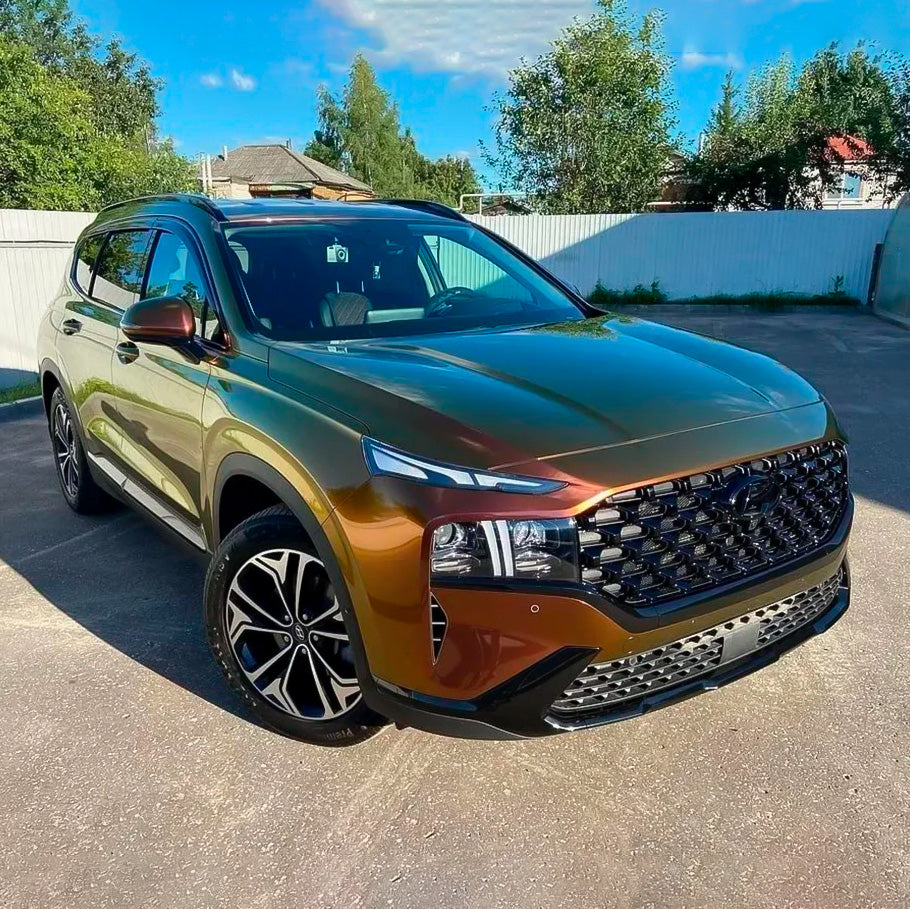 Front-angle view of SUV wrapped in glossy TeckWrap Ruby Gold (RD13-HD) Vinyl, accentuating intricate design details and vibrant metallic color transitions.