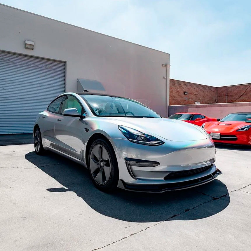 Tesla Model 3 wrapped in TeckWrap White Fireworks (RCH03-HD) Gloss Vinyl, illustrating its captivating rainbow shimmer under bright sunlight.