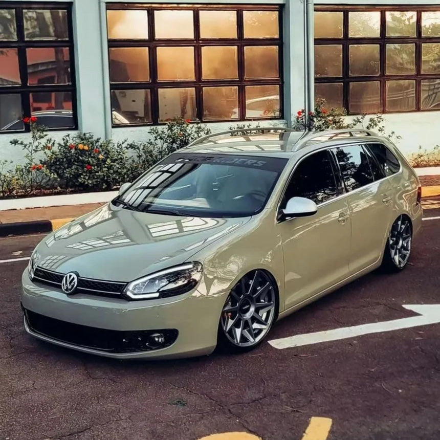Volkswagen Golf Variant wrapped in TeckWrap Moss Green CG23-HD Glossy Vinyl, parked on a city street with lowered suspension and custom wheels, showcasing the sleek olive green finish under natural light.