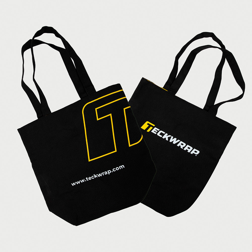 Stylish black TeckWrap canvas tote bags featuring bold yellow and white branding, perfect for carrying tools, accessories, or everyday essentials