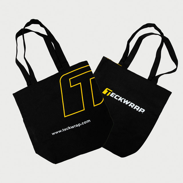 Stylish black TeckWrap canvas tote bags featuring bold yellow and white branding, perfect for carrying tools, accessories, or everyday essentials