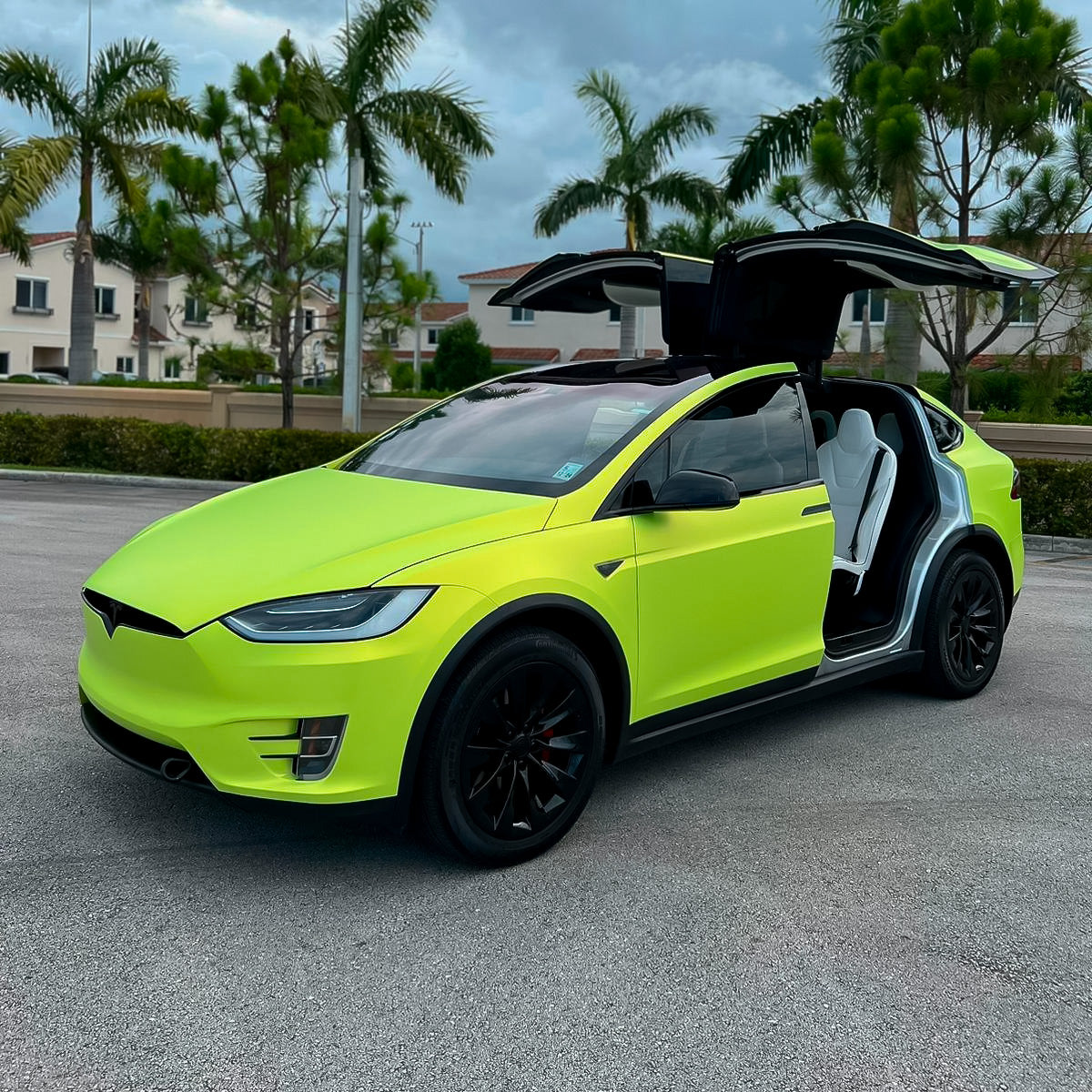 Tesla Model X with open falcon-wing doors wrapped in Lawn Green (SMT14) satin vinyl by TeckWrap, accentuating a vivid and sophisticated matte green look.