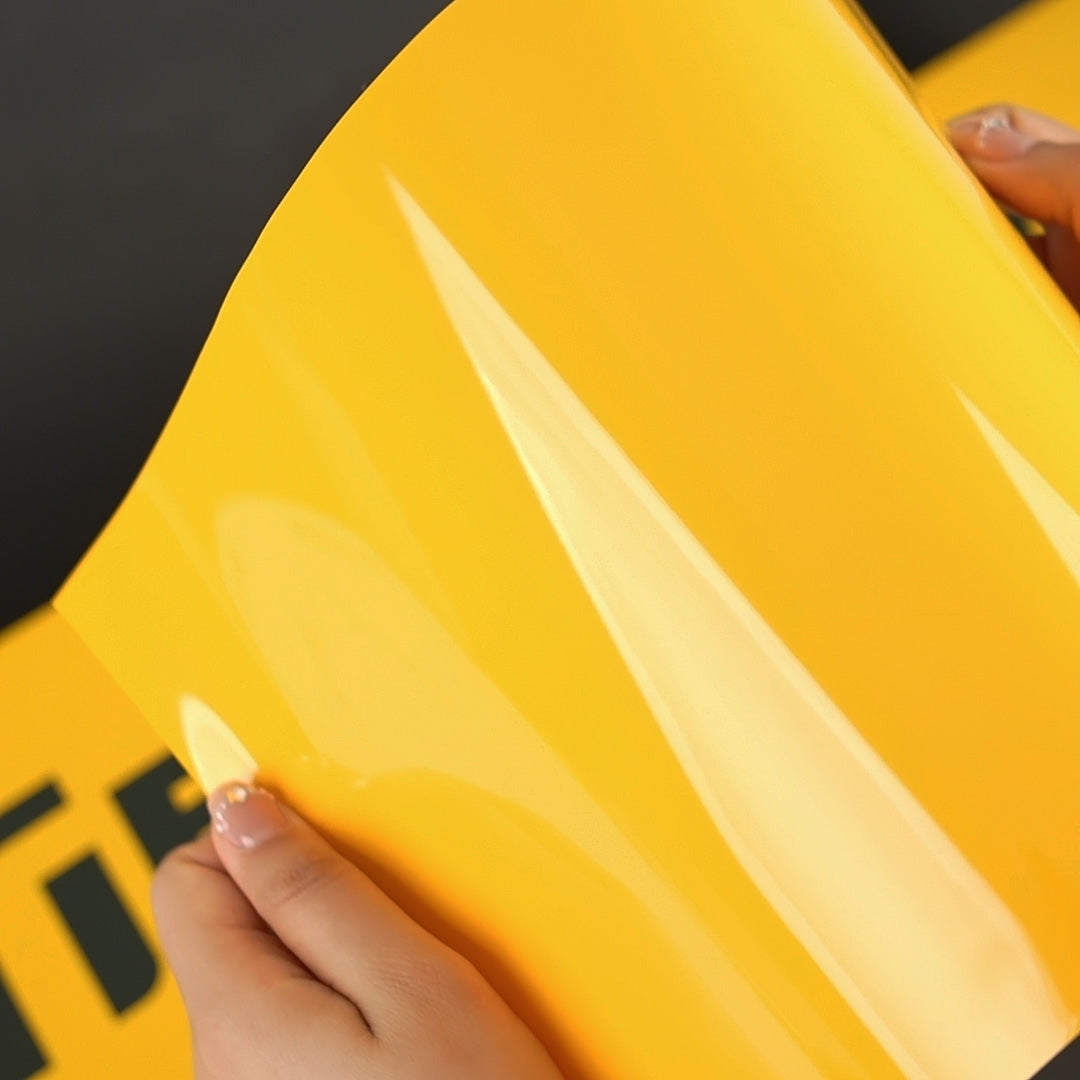 Close-up of TeckWrap Sunflower Yellow (CG12-HD) gloss vinyl wrap, highlighting its bright reflective surface and smooth texture.
