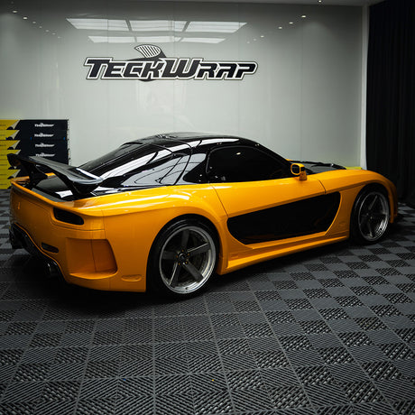 Car wrapped in TeckWrap Papaya Orange CG54-HD with black accents – Sports car fully wrapped in Papaya Orange CG54-HD TeckWrap vinyl with contrasting black panels, demonstrating dynamic color contrast and vehicle customization.