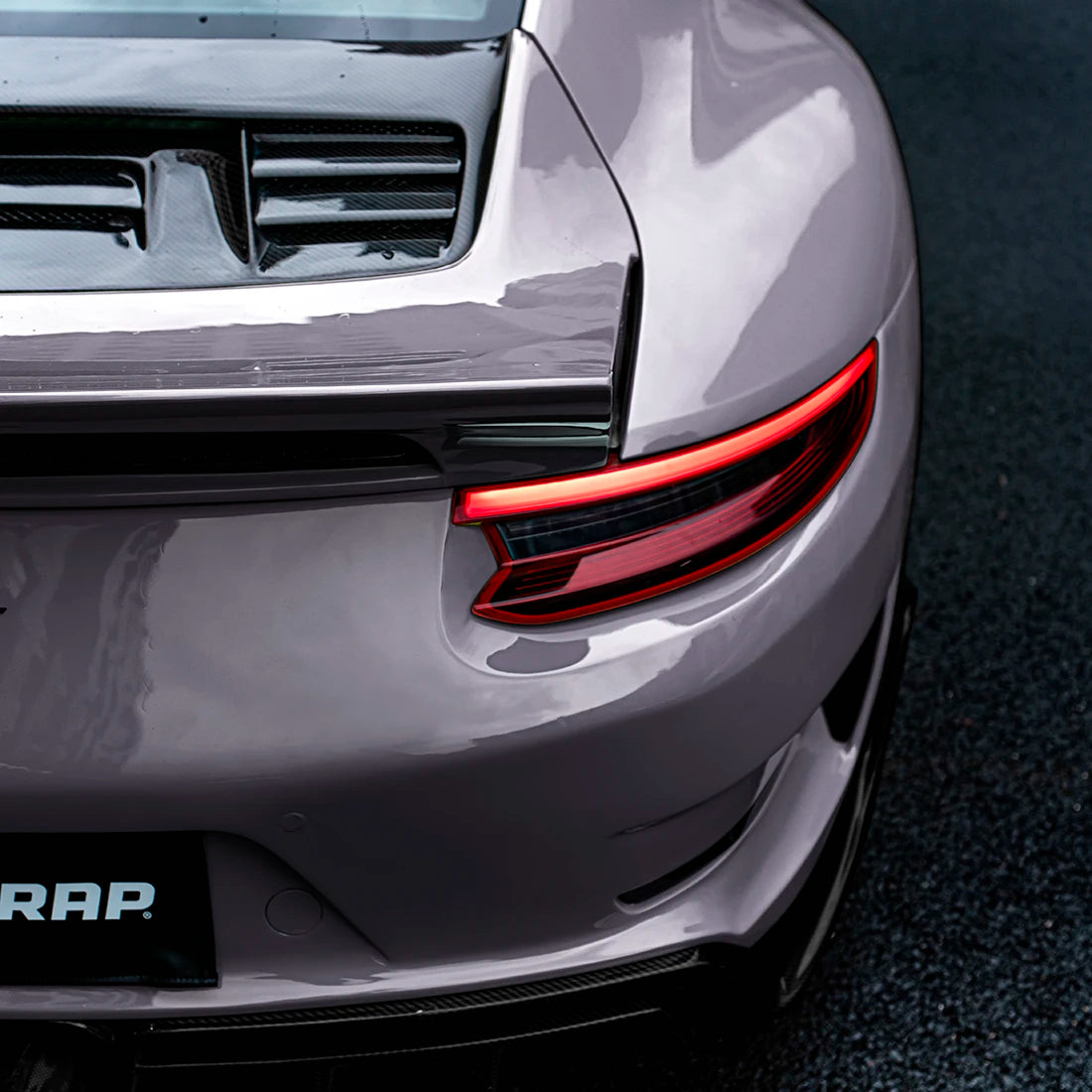 Close-up of Porsche rear with TeckWrap Dusky Grape (CG61-HD) vinyl wrap, highlighting the sleek glossy finish and detailed taillight design.