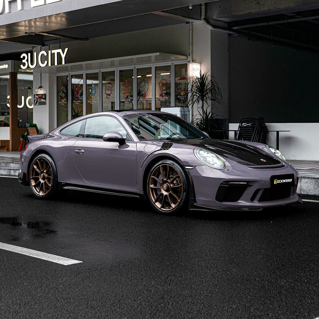 Luxury Porsche sports car wrapped in TeckWrap Dusky Grape (CG61-HD) vinyl, showcasing elegant purple-gray gloss finish with bronze alloy wheels.