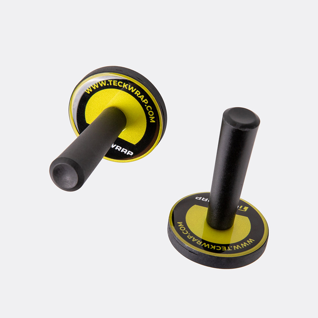 Angled view of two TeckWrap vinyl wrap magnets featuring black cylindrical handles and round yellow TeckWrap logo bases.