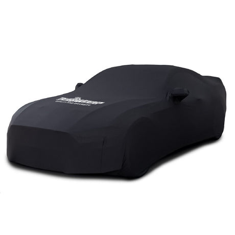 TeckWrap black vehicle cover fully protecting a car, showcasing a snug fit and branded logo on the hood.