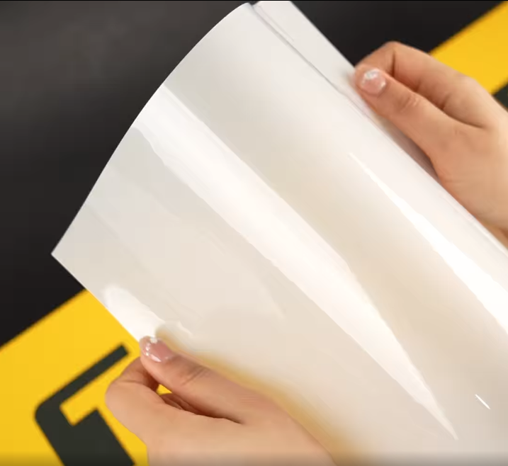 Hands showing A4 Sample of G85 Premium TeckWrap Paint Protection Film