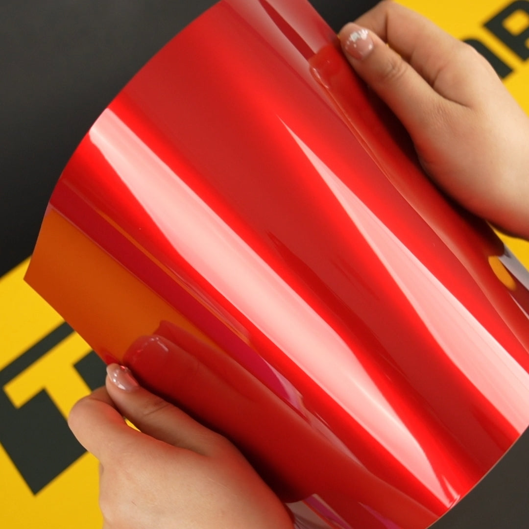 Hands holding TeckWrap A4 Samples of GAL01R-HD True Blood High Gloss Aluminum
