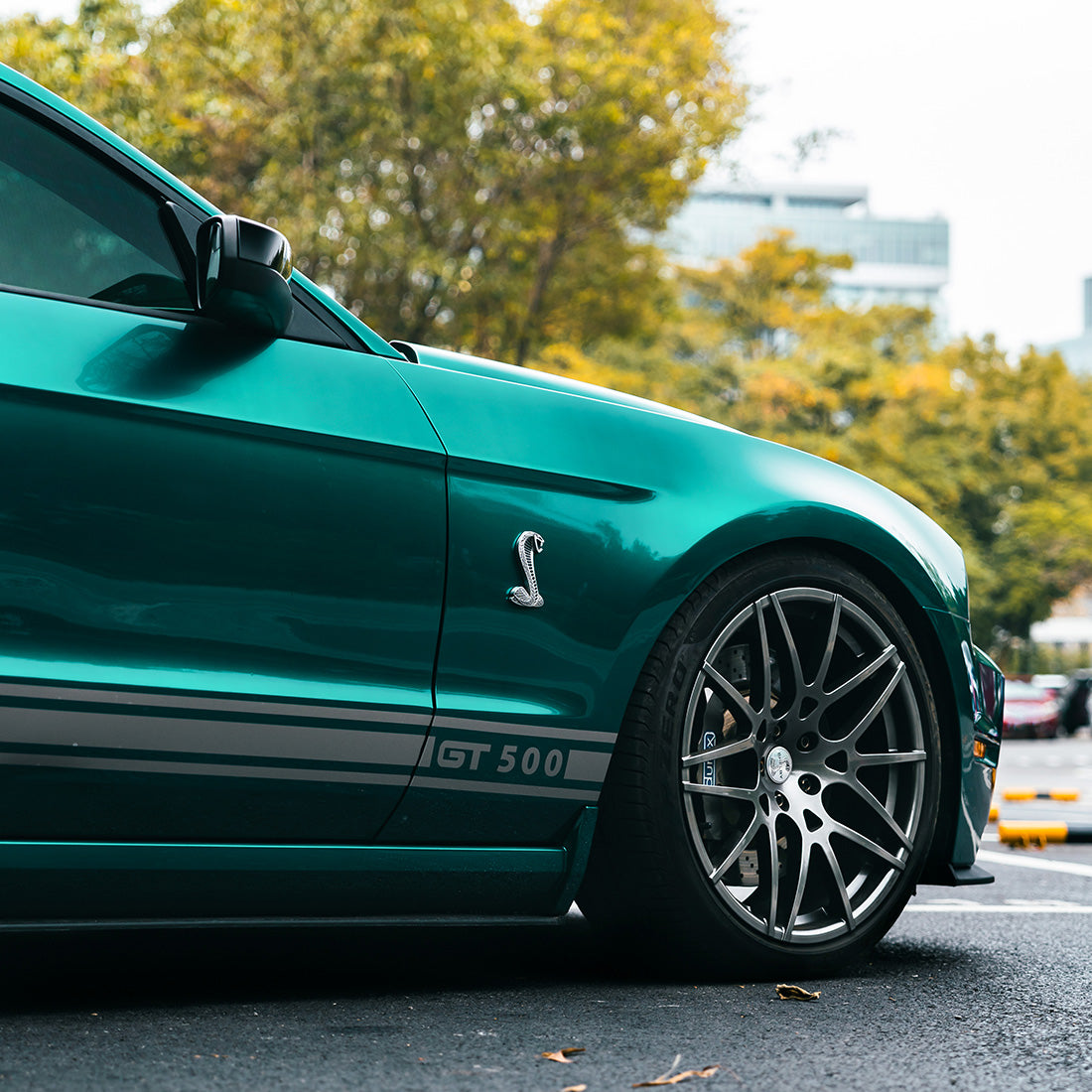 Side close-up of GT500 wheel and body wrapped in TeckWrap Azure Flame high gloss vinyl