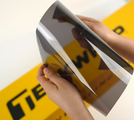 Hands showing sample of M20-2mil Car Window Tint Film by Teckwrap