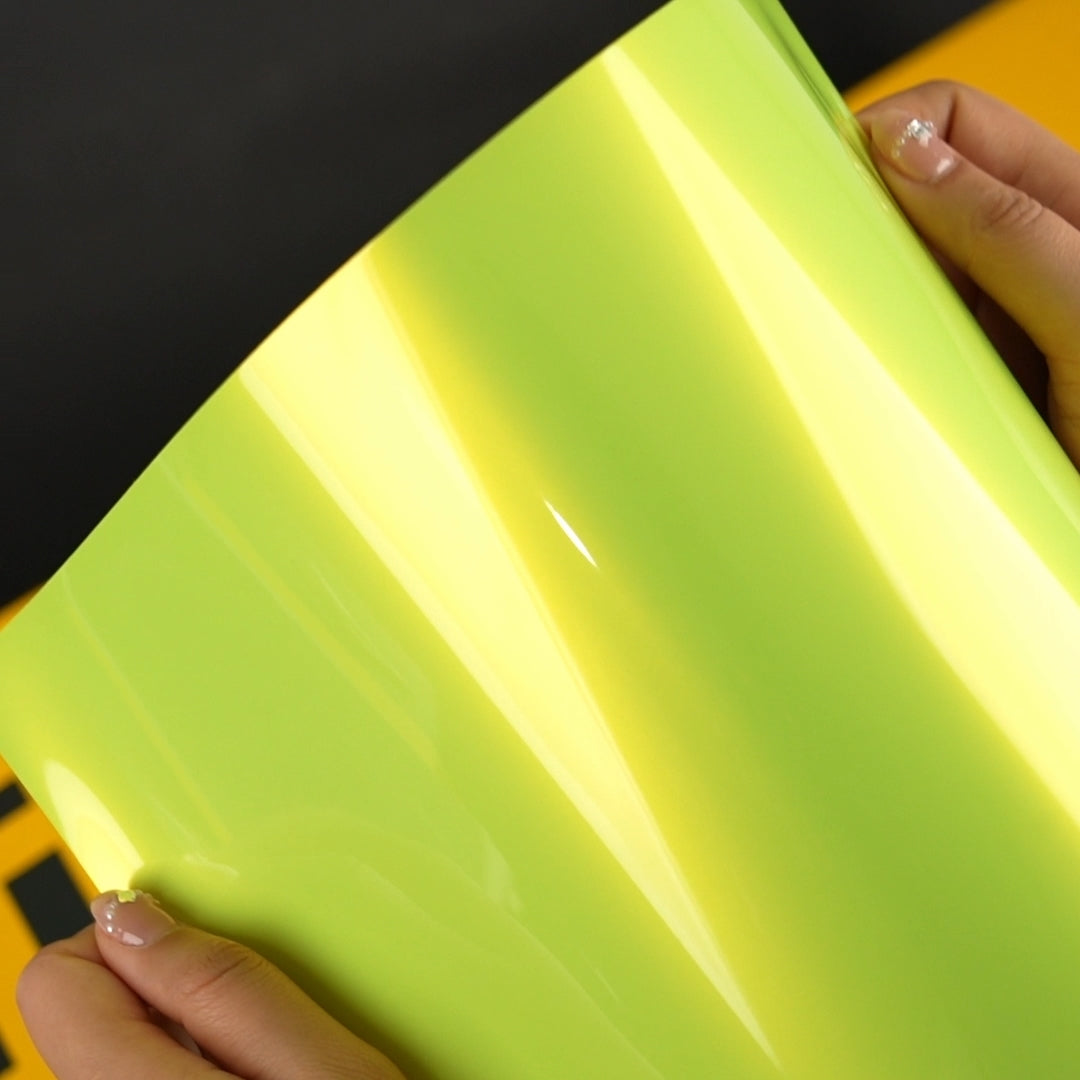 Detailed close-up of TeckWrap Acid Lime (RB07-HD) vinyl wrap, showing its glossy texture and vibrant, reflective lime color.