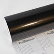 Premium black carbon fiber textured TeckWrap vinyl wrap roll with high gloss finish on cutting grid.