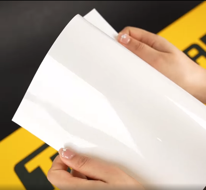 Hands showing A4 Sample of S75 Elite TeckWrap Paint Protection Film