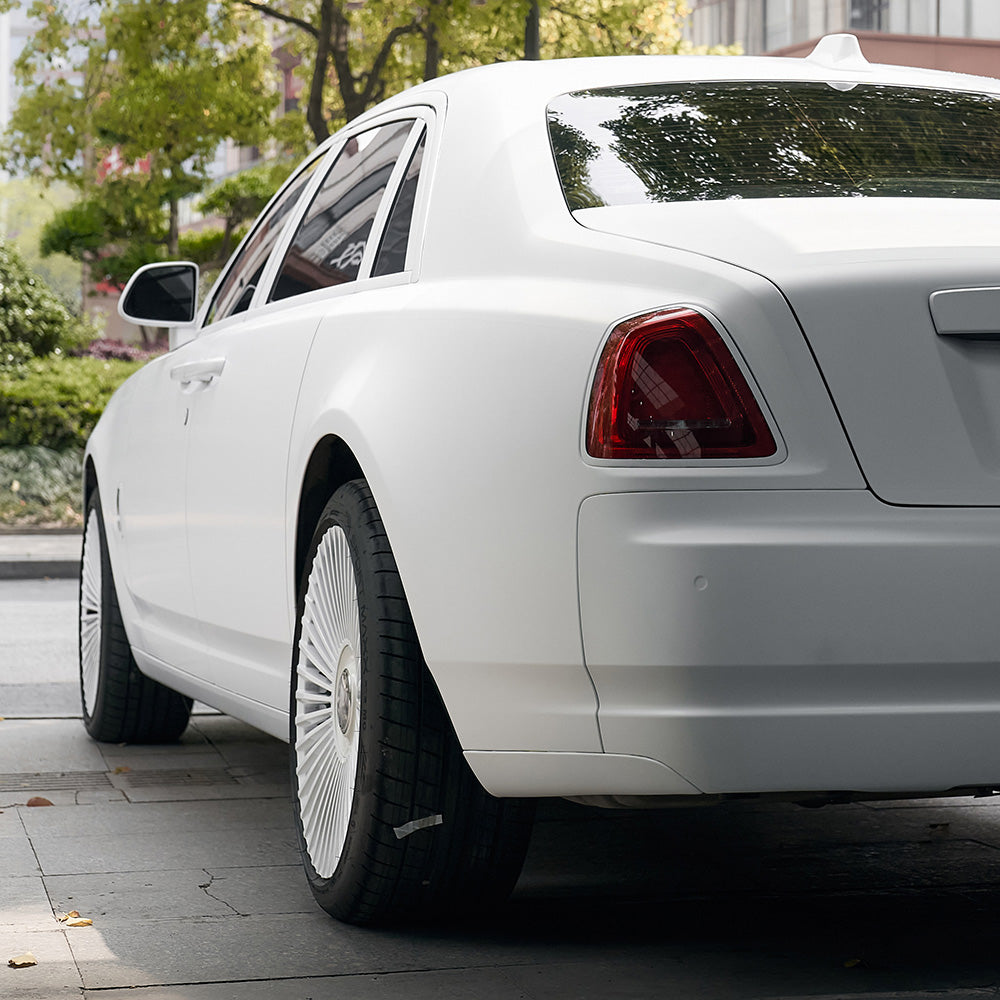 Rear side view of a luxury car wrapped in TeckWrap Alaska White SCM02 matte vinyl, highlighting smooth contours and refined satin finish for an elegant automotive appearance