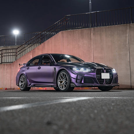 BMW wrapped in TeckWrap Satin Venetian Violet (SMT03) vinyl, showcasing a sophisticated satin purple finish, parked under bright urban lighting.
