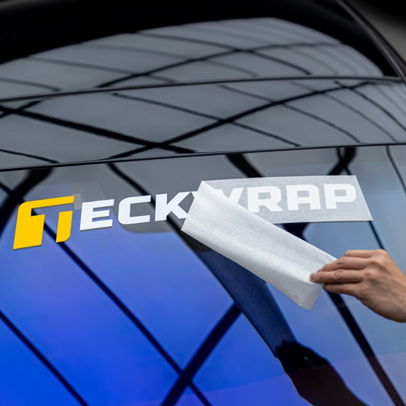 Peeling transfer paper from TeckWrap logo sticker after applying on car window