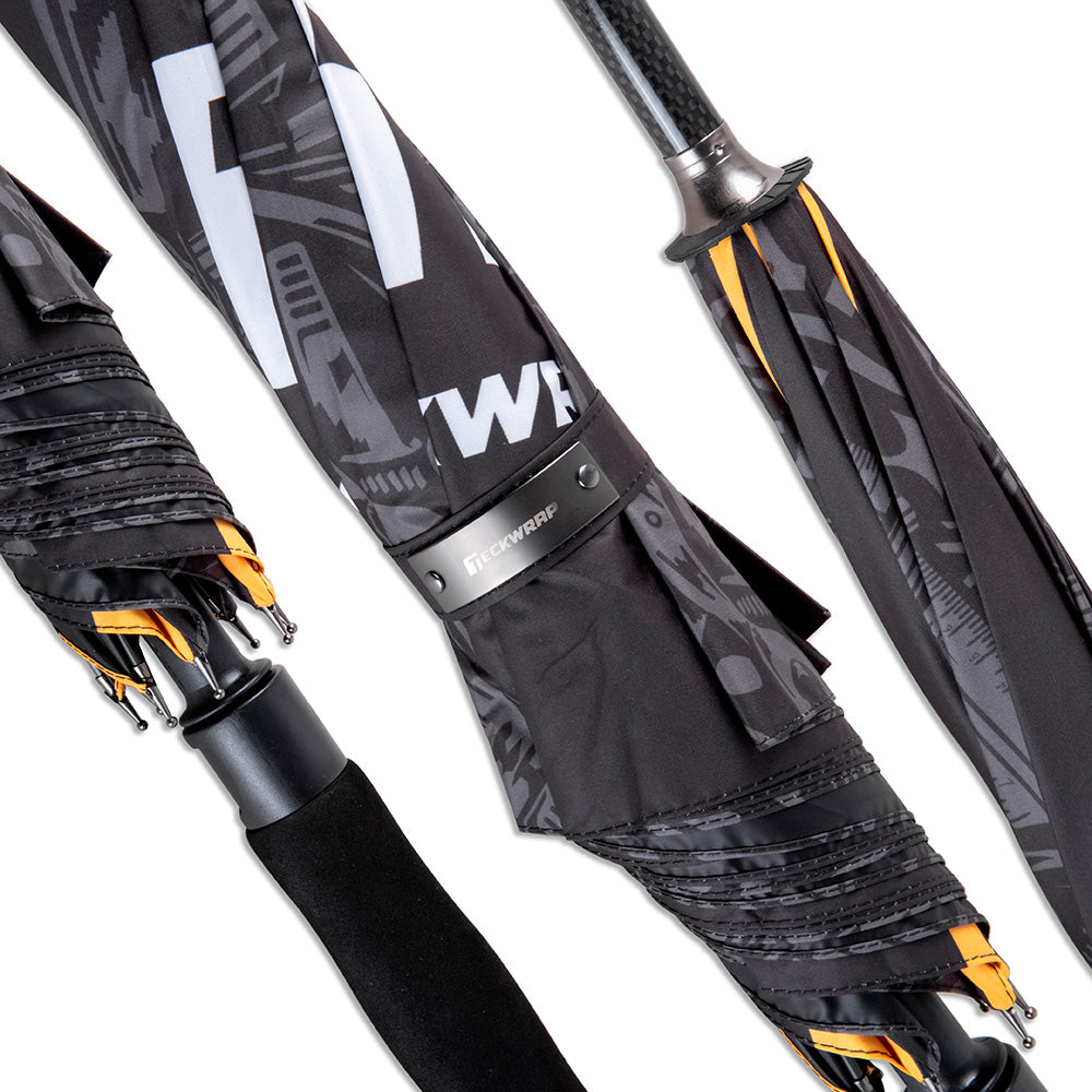 Close-up view of TeckWrap umbrella handle and folded canopy showing intricate logo details.