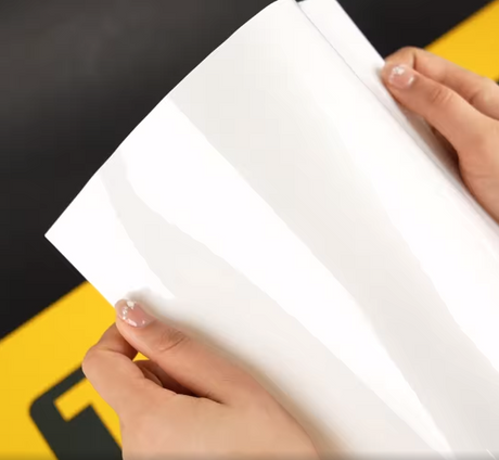 Hands showing A4 Sample of X75 Core TeckWrap Paint Protection Film