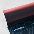 Roll of TeckWrap Madeira Red (RD17-HD) Chameleon Metallic Vinyl Wrap, emphasizing the color-shifting effect from deep burgundy to fiery copper-red hues.