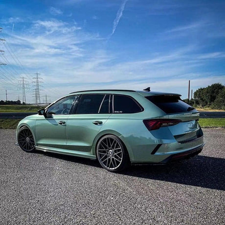 Side profile of a car elegantly wrapped in Teckwrap Gloss Antique Green (HM16-HD), highlighting its sophisticated, timeless green hue under natural sunlight.