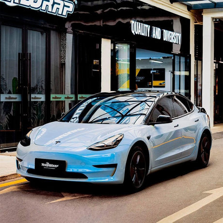 Front angle view of a Tesla Model 3 wrapped in Teckwrap Gloss Azure Maya Blue (DS04-HD), illustrating the sleek, premium finish and eye-catching light blue color enhancing the vehicle's modern aesthetics.