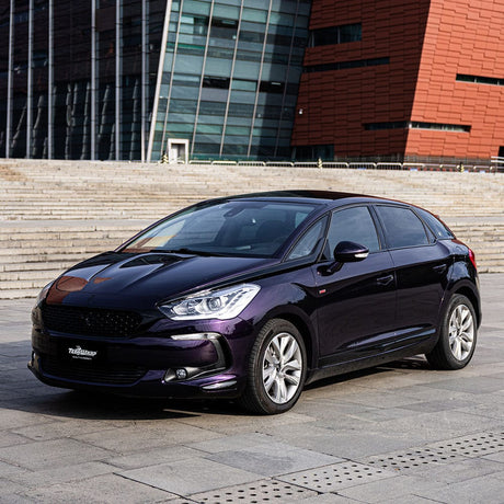 Stylish hatchback wrapped in TeckWrap Gloss Black Cherry Ice (HM08-HD) Vinyl, displayed outdoors showcasing its sleek, dark purple glossy finish