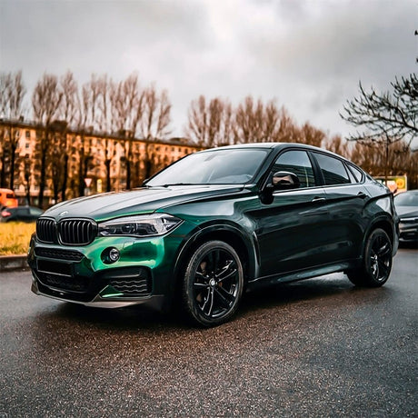 BMW SUV elegantly wrapped in TeckWrap Hunter Green (GAL29-HD) gloss vinyl, emphasizing its glossy, sophisticated finish in natural outdoor lighting.