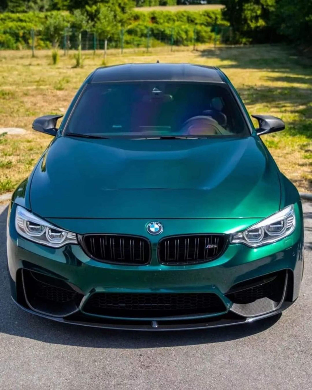 Full frontal shot of a BMW sedan featuring TeckWrap Hunter Green (GAL29-HD) vinyl wrap gloss, spotlighting the stunning reflective finish.