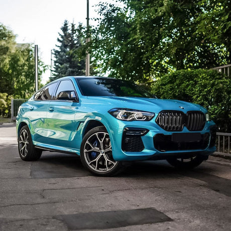 BMW Wrapped in TeckWrap Sea Turquoise Gloss Vinyl (RB16-HD) - Front and side view of a sleek BMW SUV showcasing the brilliant turquoise gloss vinyl wrap, accentuating the car's curves and luxurious aesthetic.