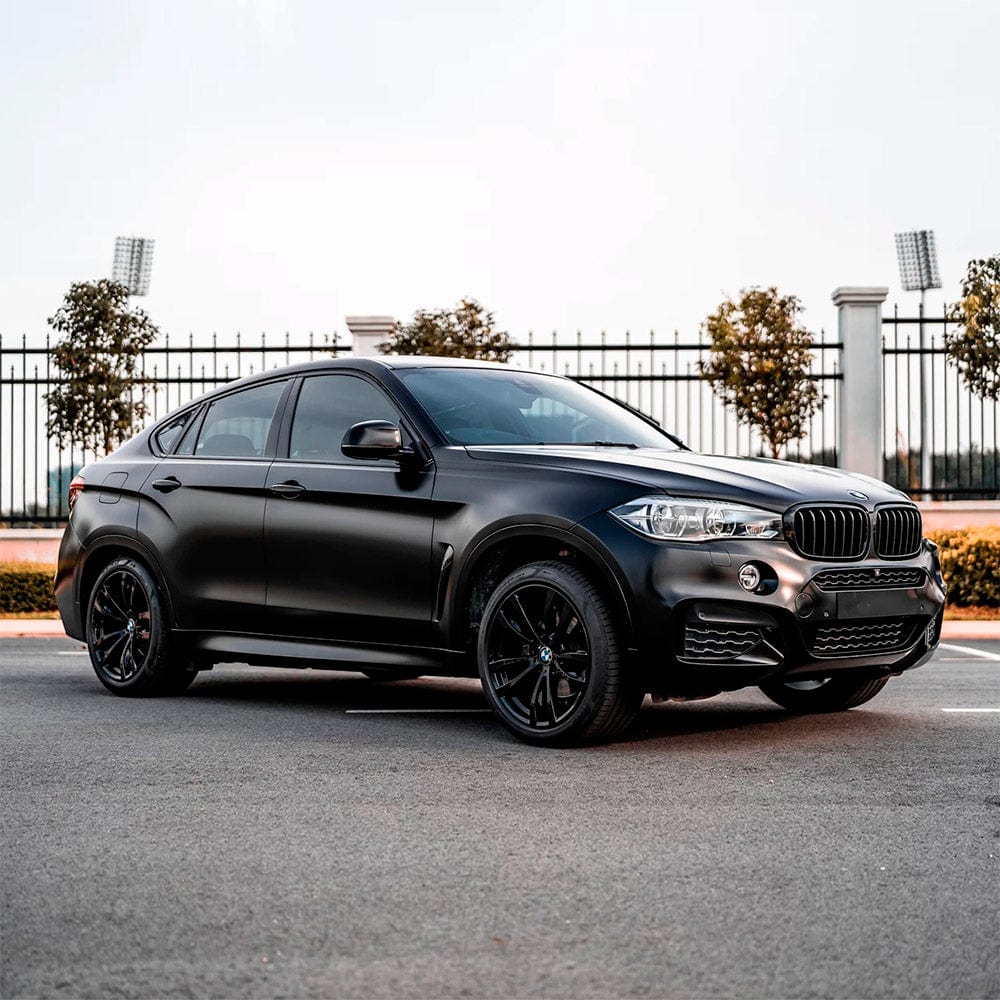 Side view of a BMW SUV wrapped with TeckWrap Sable Black (TC01) Matte Vinyl Wrap, parked outdoors, emphasizing the wrap’s subtle yet striking matte appearance that enhances the vehicle’s sporty profile.