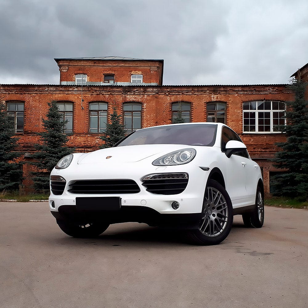 Front-angle view of a Porsche wrapped in Teckwrap White Matte (CM02) vinyl wrap, emphasizing the elegant, sleek matte white appearance.