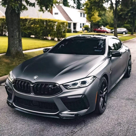 Front view of a sleek BMW wrapped in TeckWrap Satin Black Silver (HM02-R) Vinyl Wrap, parked in a residential area, displaying the elegant satin finish and subtle silver undertones.