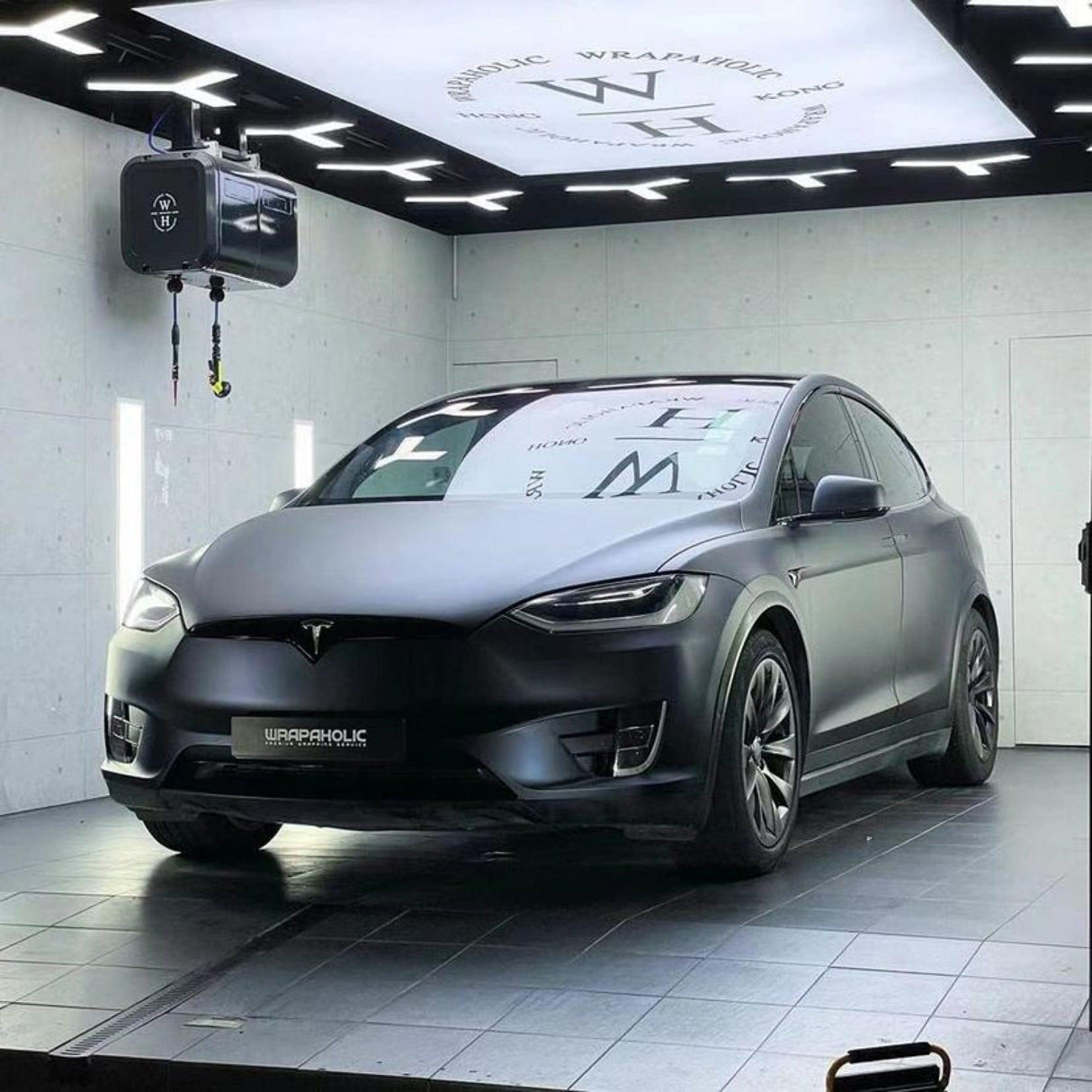 Side-front perspective of a Tesla featuring TeckWrap Satin Boysenberry Black (SMT04) wrap, showcasing its sleek satin finish