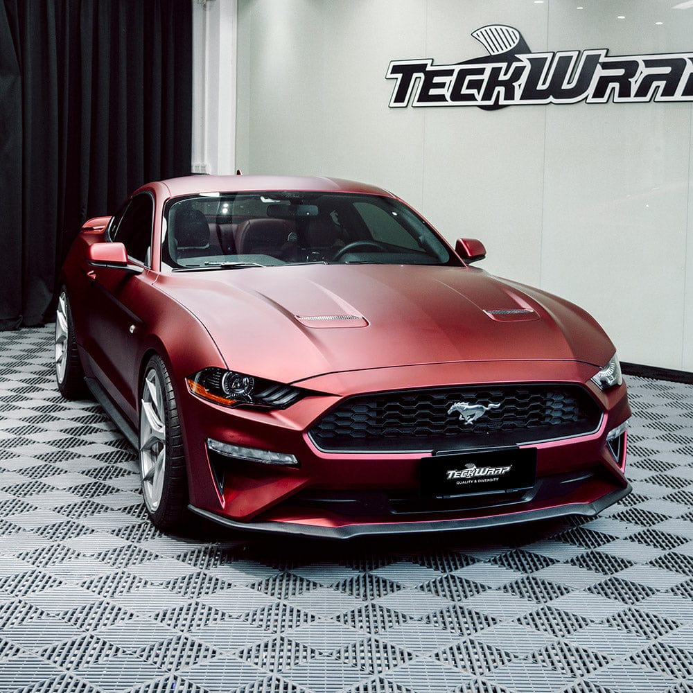 Ford Mustang fully wrapped in TeckWrap Satin Metallic Oxide Red (SMT18) vinyl with a satin metallic finish on display at a wrap studio.