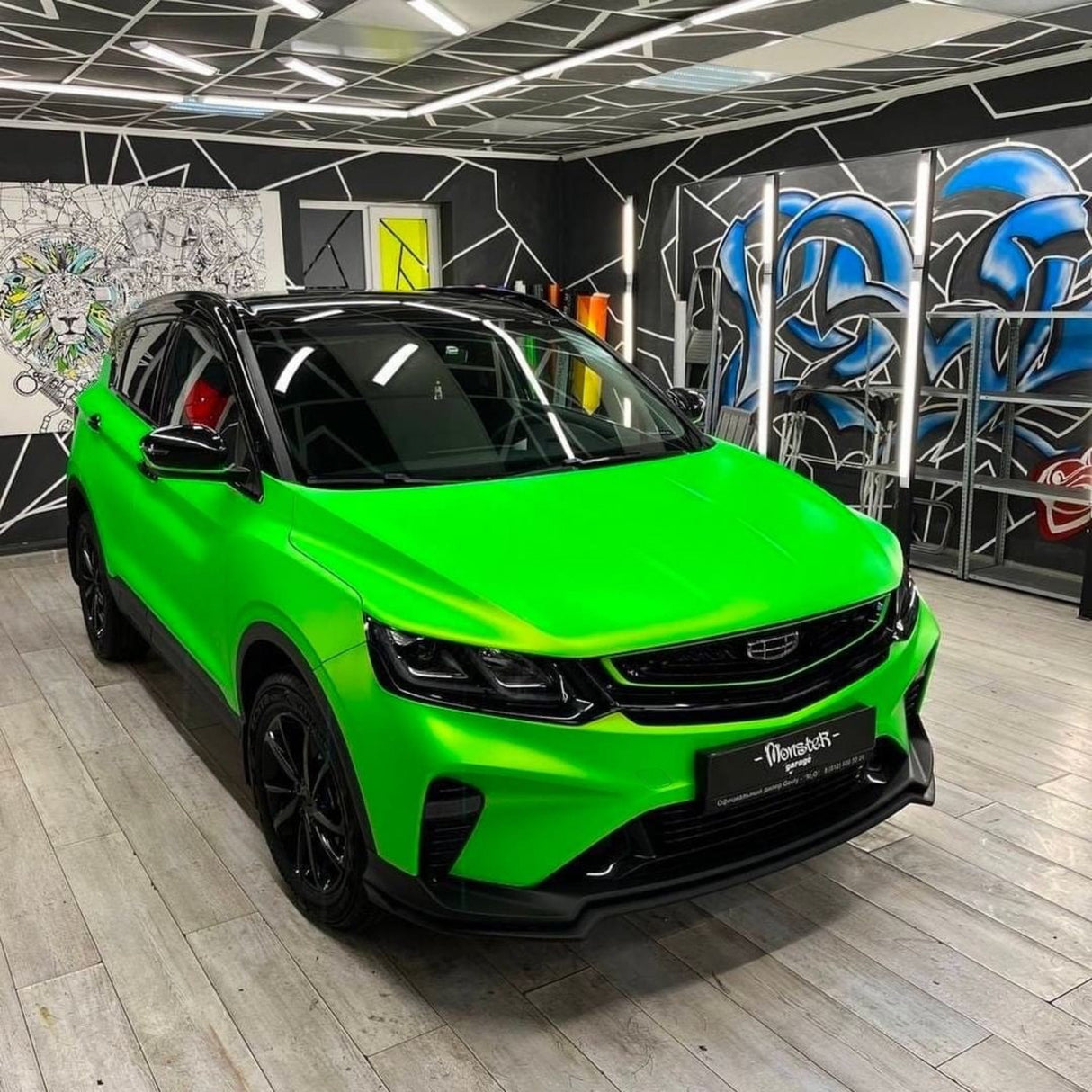 Front view of a car wrapped in Paradise Green Satin Vinyl (SMT12), capturing its striking satin green appearance in a professional automotive workshop.