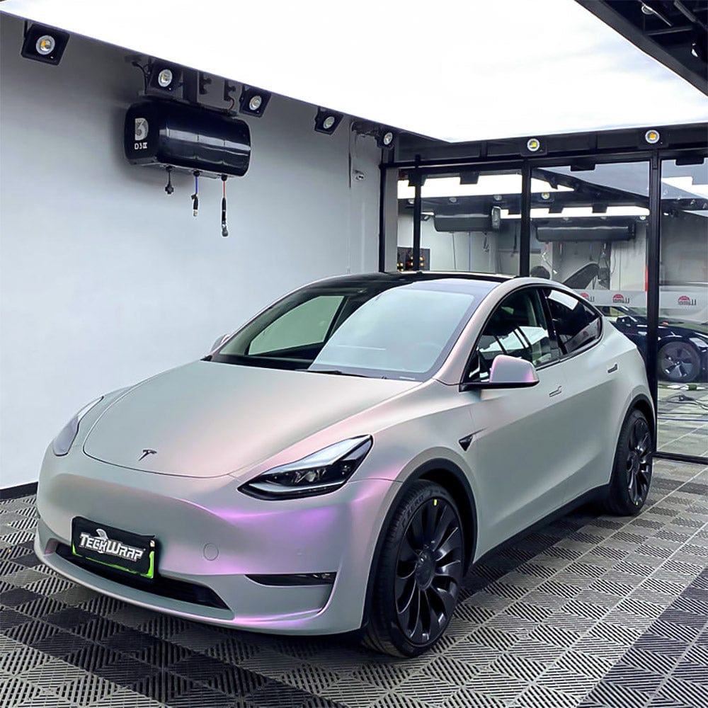 Tesla car elegantly wrapped in TeckWrap Silver Sunset Matte Satin Vinyl, presenting a sophisticated look with iridescent silver and gentle pink undertones in a showroom setting.