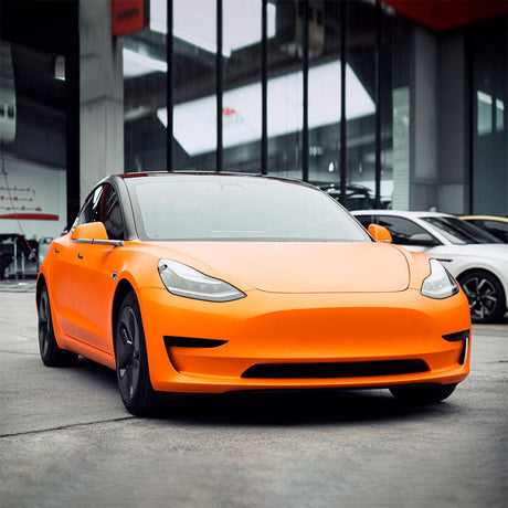 Tesla wrapped in TeckWrap Solar Orange Satin Vinyl Wrap (SMT10), displaying a stunning, bold appearance with a premium matte orange finish.