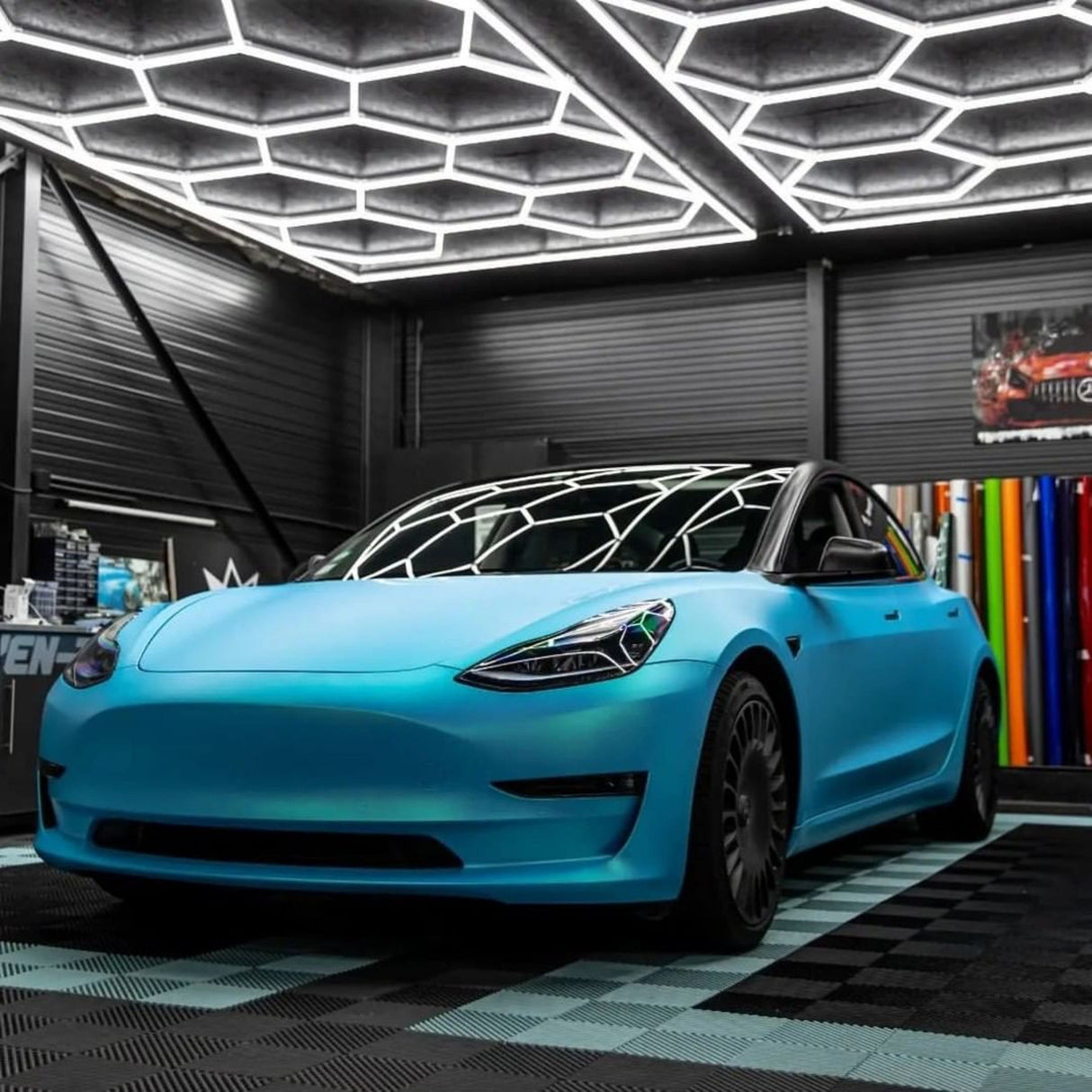Front View of a Tesla Model 3 Professionally Wrapped in TeckWrap Surf Blue (SMT11) Satin Vinyl Wrap, Displaying Sleek Matte Finish under Indoor Lighting