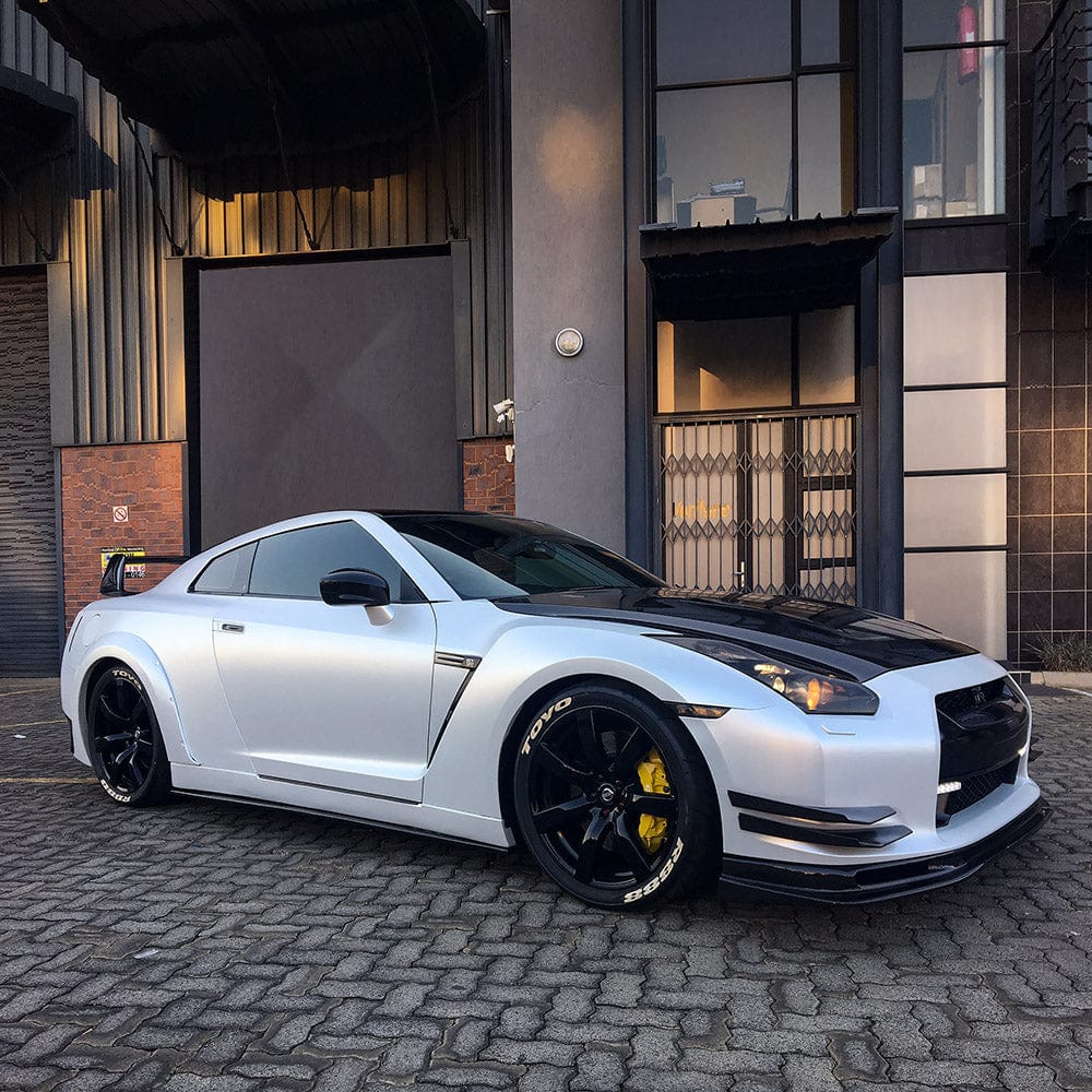 Side view of a sports car wrapped in Teckwrap White Satin (CK903) vinyl wrap, clearly displaying its premium satin white finish that accentuates the vehicle's sleek lines.