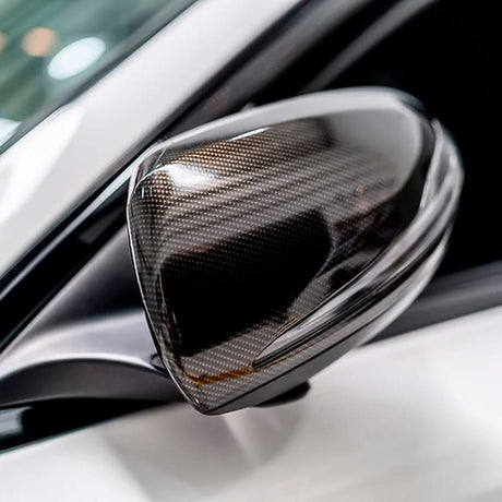 Car side mirror wrapped in TeckWrap Ceramic Carbon (RCF03) vinyl, demonstrating its sophisticated glossy carbon fiber look and protective qualities.