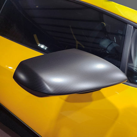 Side mirror of a yellow sports car wrapped in TeckWrap Matte Ceramic Carbon (RCF03M) Vinyl, clearly displaying the wrap’s smooth matte finish and realistic carbon fiber detailing.