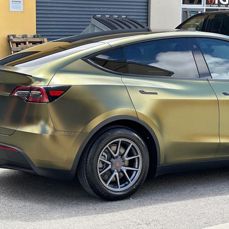 Rear-side view of Tesla Model Y in satin metallic Greenfinch Gold vinyl wrap by TeckWrap