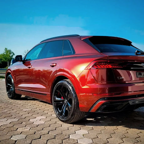 Detailed rear-angle view of an Audi Q8 featuring Supreme Red Gloss Metallic Vinyl Wrap (GAL26-HD), highlighting the wrap's high-gloss finish, intense metallic shine, and vivid red color, creating a visually striking and premium appearance perfect for automotive enthusiasts seeking distinctive style.