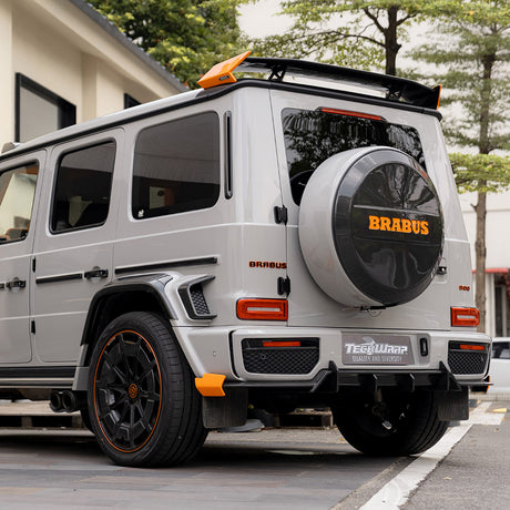 Rear-side angle of a Brabus G-Class SUV wrapped in TeckWrap Vintage Grey (CG47-HD) high-gloss film, emphasizing branding and finish.