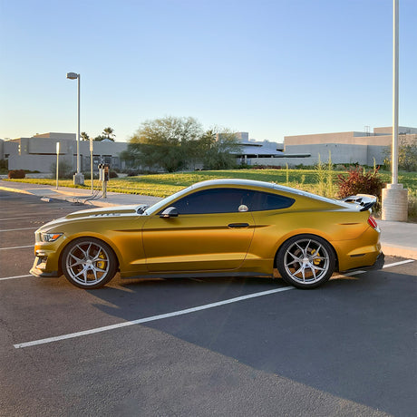 Side profile of Ford Mustang featuring vibrant TeckWrap Golden Yellow (VCH408-S) Satin Vinyl, parked outdoors.