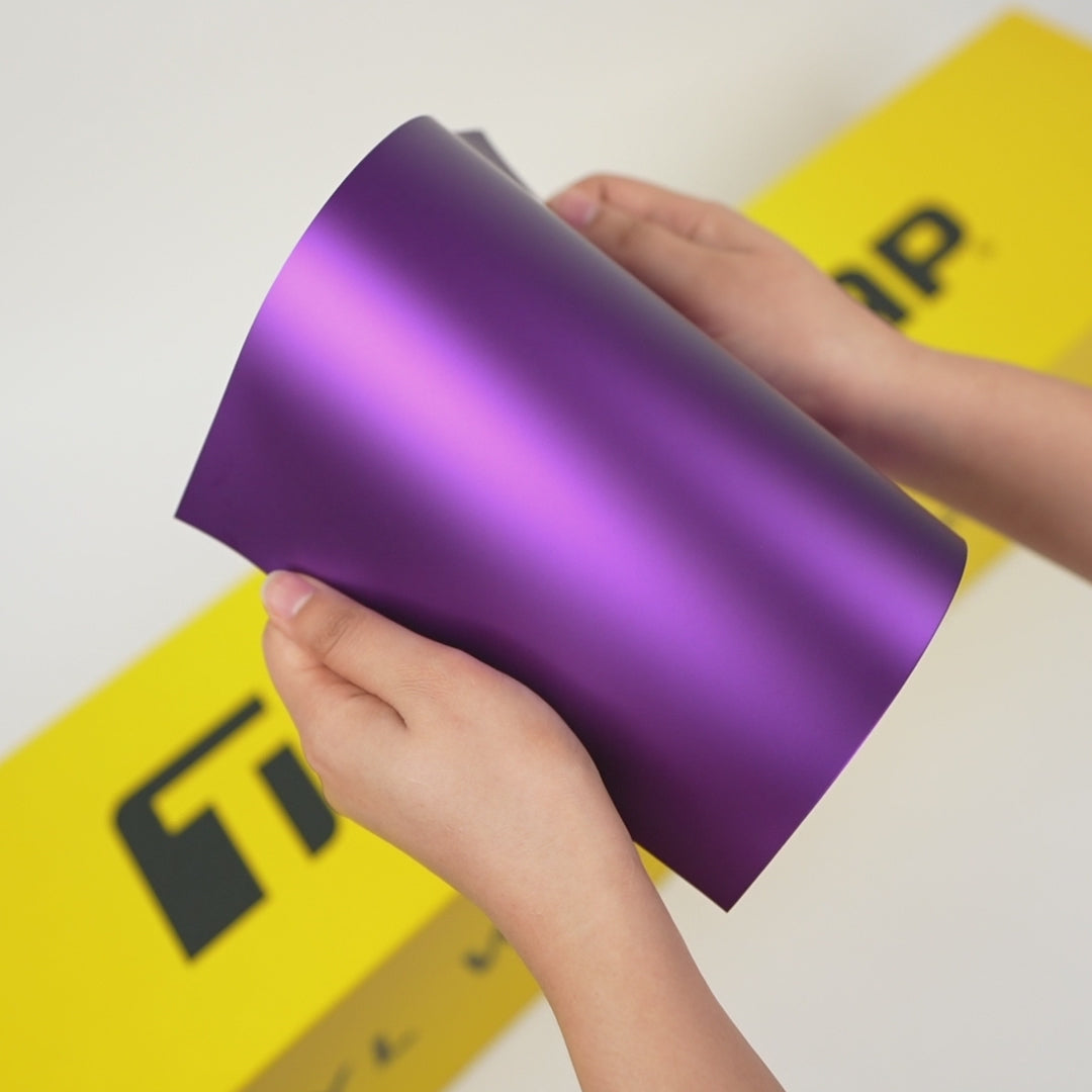 Hands holding sample sheet of TeckWrap Deep Lavender (SMT20) satin matte car wrap film